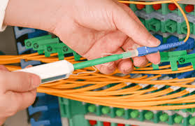 Technician using a fiber cleaning pen on a patch panel